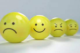 Three yellow spheres with different facial expressions on them; sad, happy and angry.